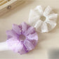 Gifty tulle scrunchie styled on a wrist with delicate ruffled texture