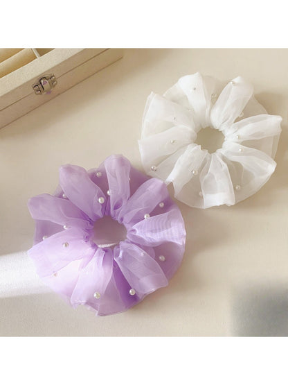 Gifty tulle scrunchie styled on a wrist with delicate ruffled texture