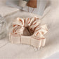 Scrunchie held between fingers showing size and delicate fabric texture