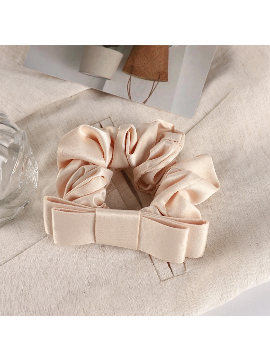 Scrunchie held between fingers showing size and delicate fabric texture
