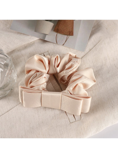 Scrunchie held between fingers showing size and delicate fabric texture