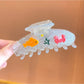 Beau fish decor claw clip held in hand showing size and detail