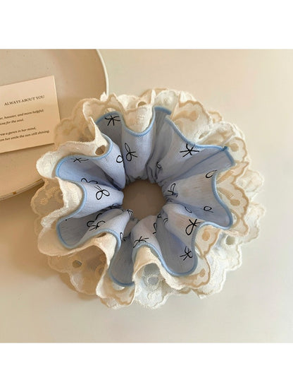 Close-up of Gifty bow print ruffled scrunchie in pastel colors on white background