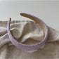 Purple wide edge headband folded to show flexibility and material