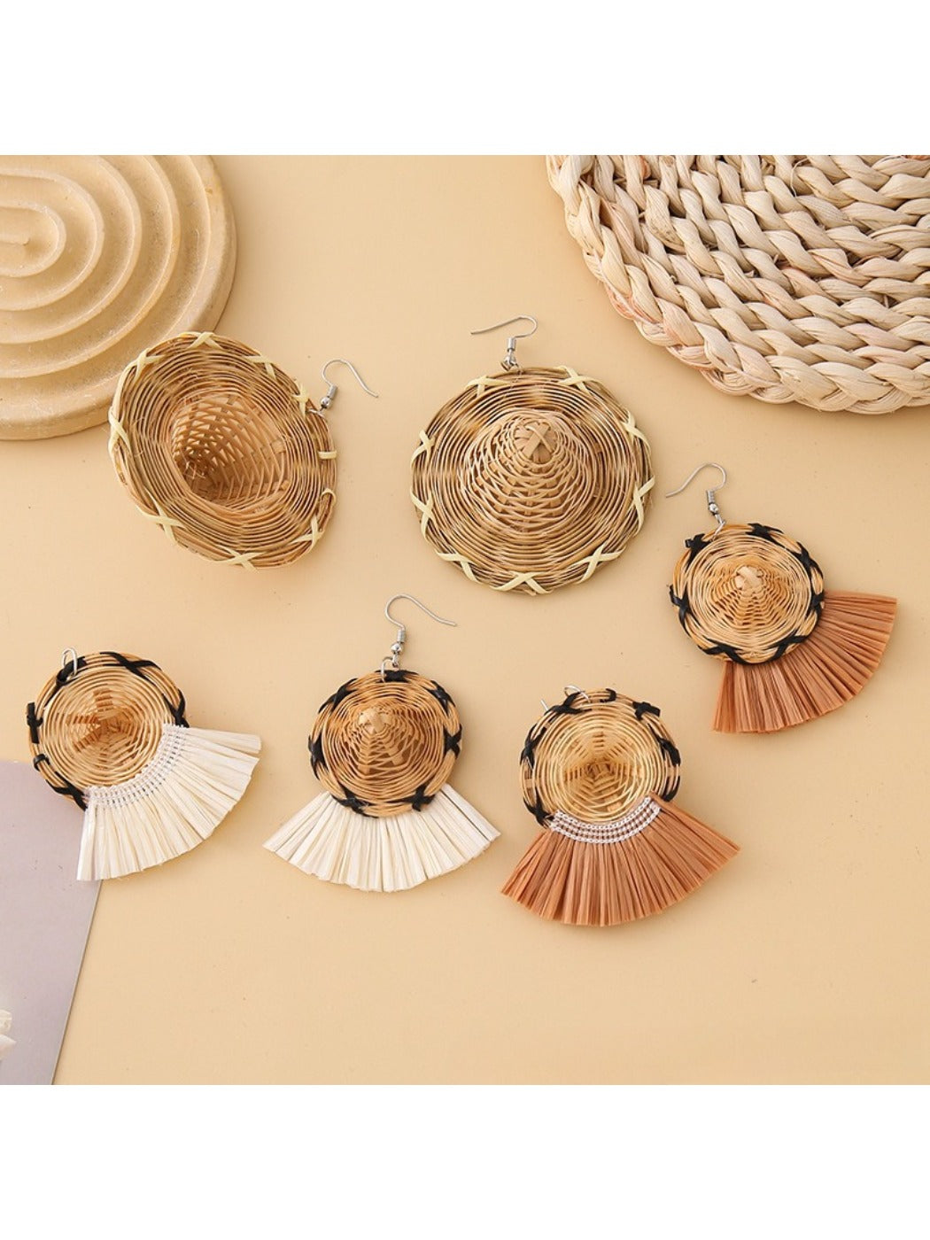 Pair of straw hat shaped earrings displayed on a jewelry stand