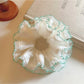 Side view of Gifty white tulle double scrunchie with green trim