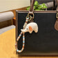 Elephant charm keychain resting on a colorful fabric surface