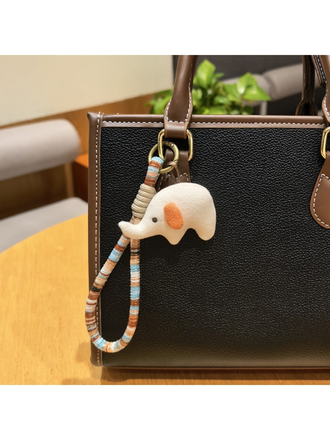 Elephant charm keychain resting on a colorful fabric surface