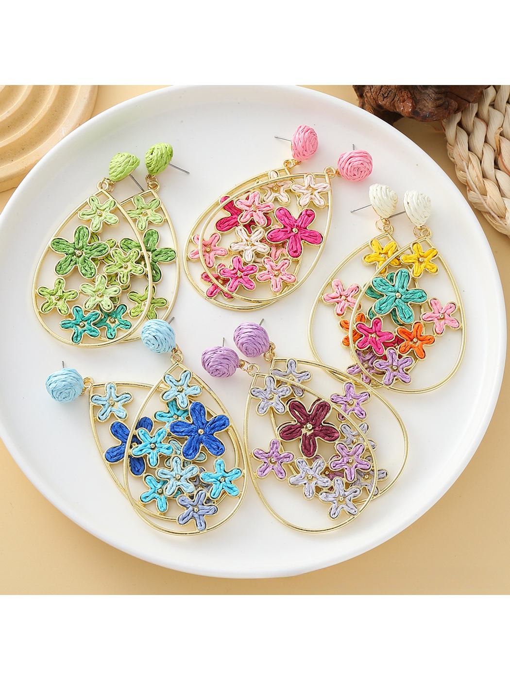 Close-up of Earedge floral raffia statement drop earrings on white background