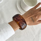 Lovra asymmetrical bangle bracelet in natural light showing metallic sheen