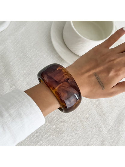 Lovra asymmetrical bangle bracelet in natural light showing metallic sheen