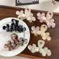 Beau elegant floral hair claw clip in cream and gold tones on white background