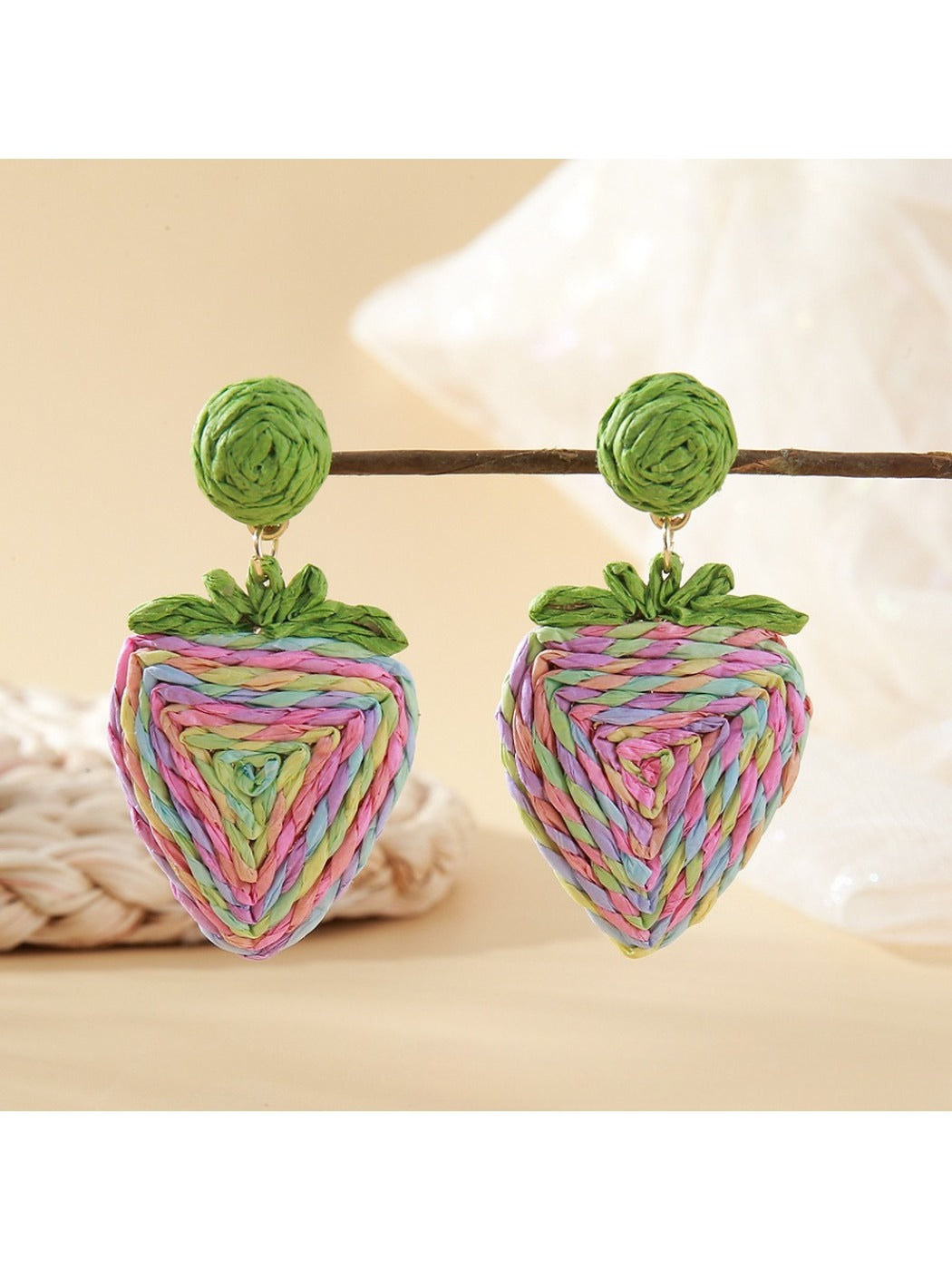 Detailed shot of green raffia leaves on strawberry earrings