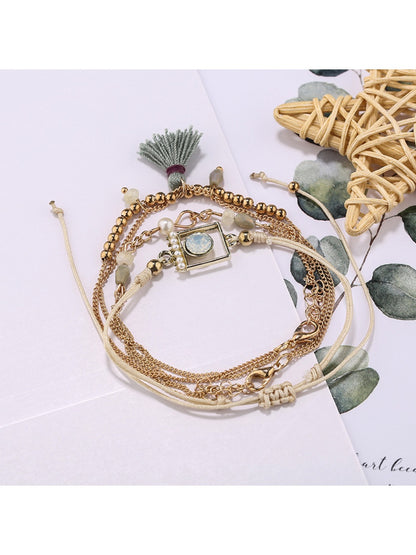Model wearing Lovra small bead bracelet with tassel pendant on wrist