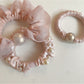 Pink mini scrunchie displayed alongside matching hair accessories