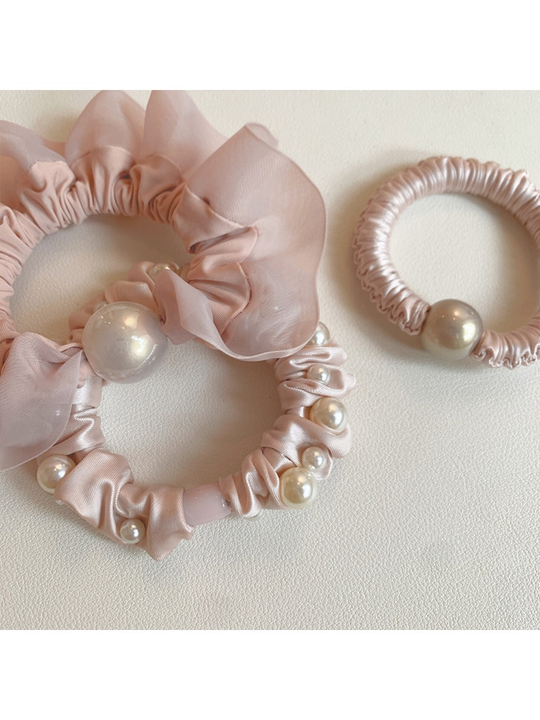 Pink mini scrunchie displayed alongside matching hair accessories