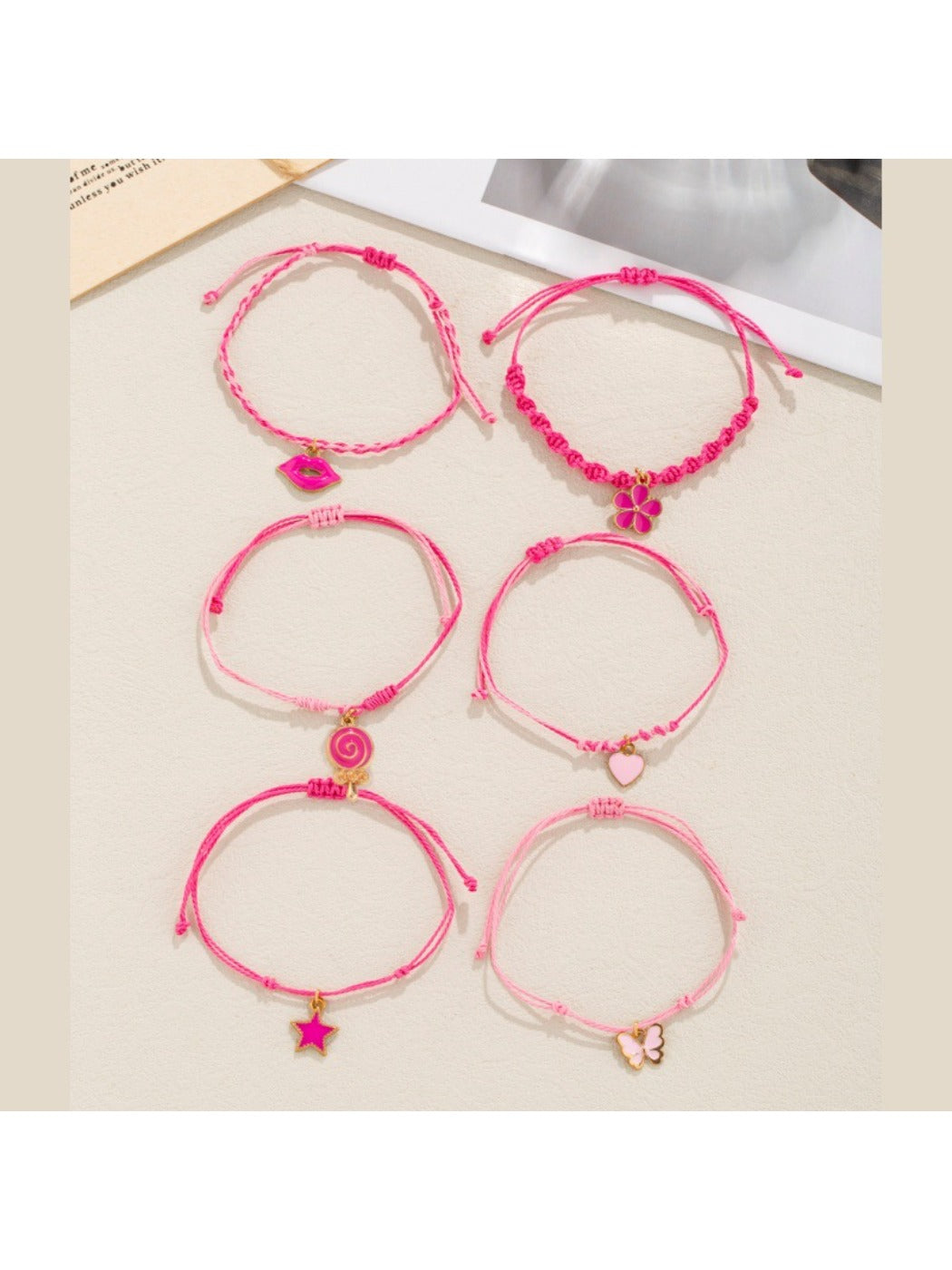 Lovra pink pendant layered bracelet with delicate chains and small charms on a white background