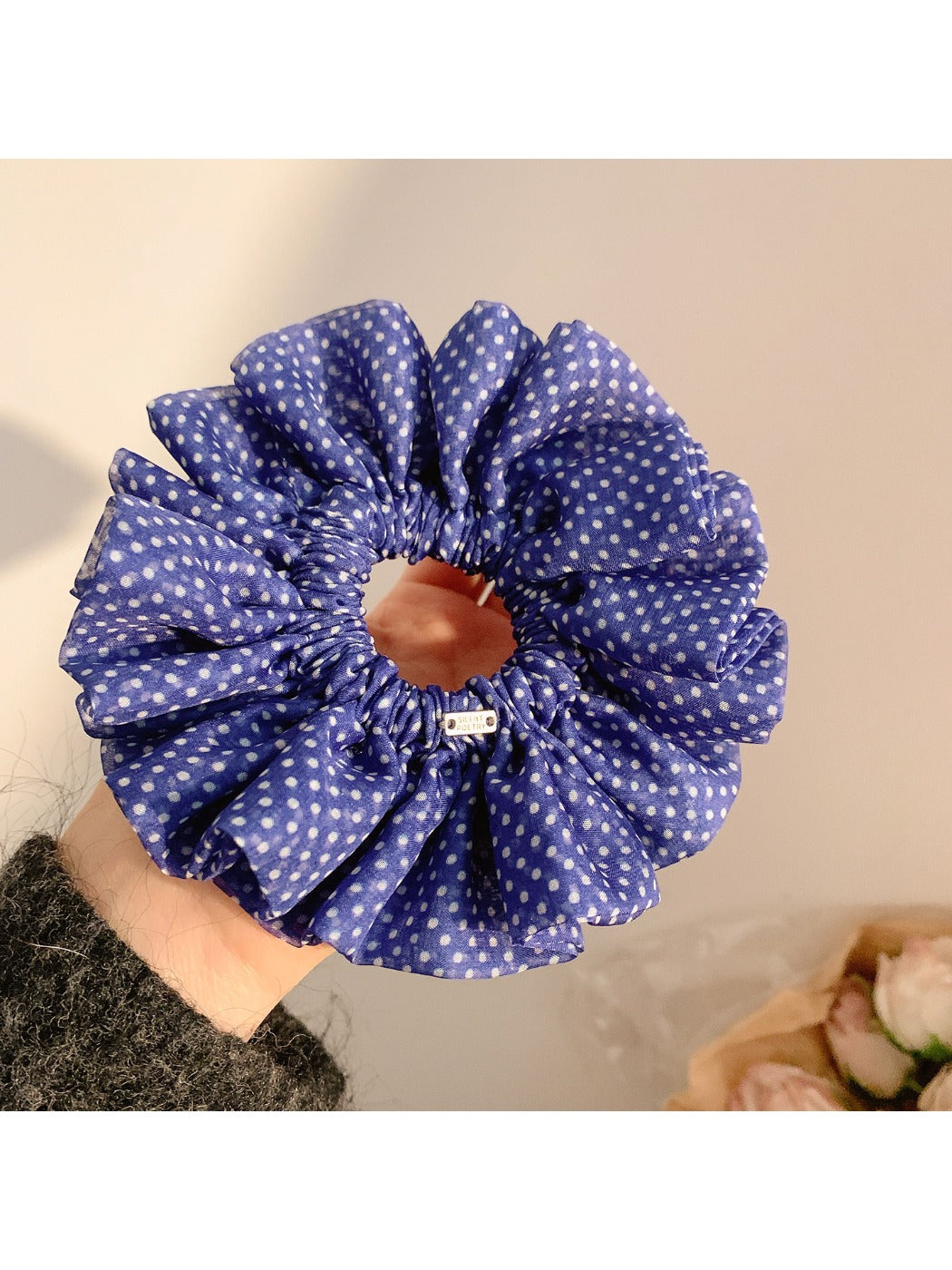 Gifty polka dot scrunchie styled on a wrist with ruffled edges visible