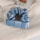 Scrunchie paired with matching pastel accessories on a light surface