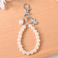 Hand holding Keypus beaded bag charm keychain showing its size and details