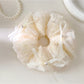 Side view of Gifty bow embellished scrunchie highlighting the gathered fabric design
