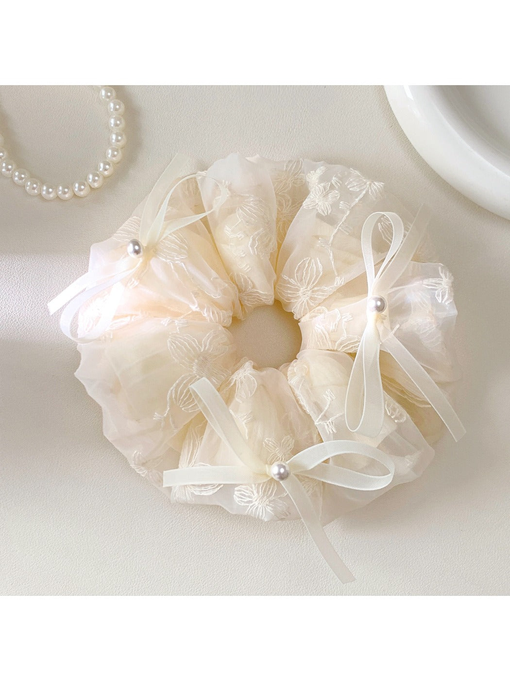 Side view of Gifty bow embellished scrunchie highlighting the gathered fabric design