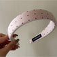 Gifty headband placed next to matching accessories on wooden surface