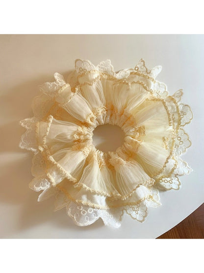 Beige tulle scrunchie with lace trim displayed in natural light
