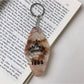Colorful diamond pendant keychain shown with keys and a wallet on a table