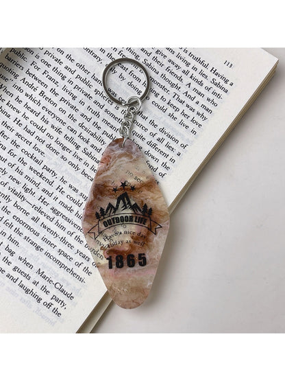 Colorful diamond pendant keychain shown with keys and a wallet on a table