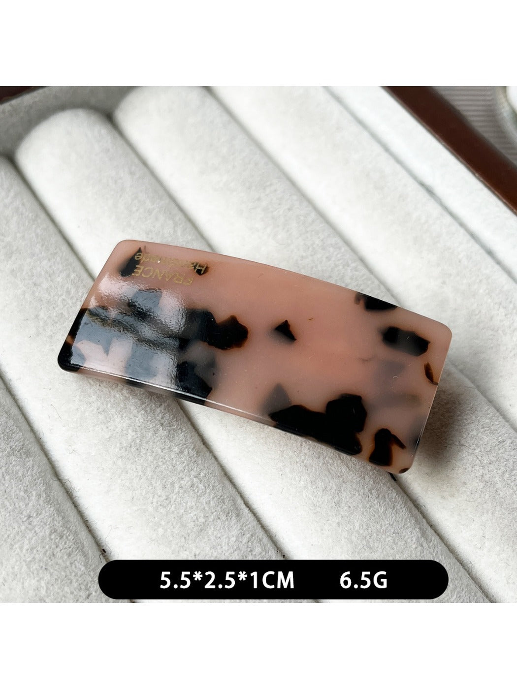 Beau curved bar hair clip in natural light on fabric background