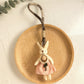 Hand holding the minimalist bunny pendant keychain with natural lighting