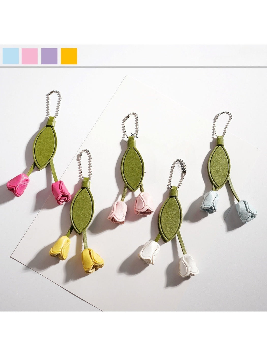 Close-up of a cute tulip flower shaped keychain with pink petals and green leaves