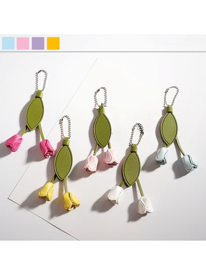 Close-up of a cute tulip flower shaped keychain with pink petals and green leaves