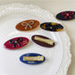 Beau hair clip held in hand displaying size and oval butterfly shape