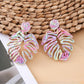 Earedge raffia woven hollow leaf shaped earrings hanging on a jewelry stand
