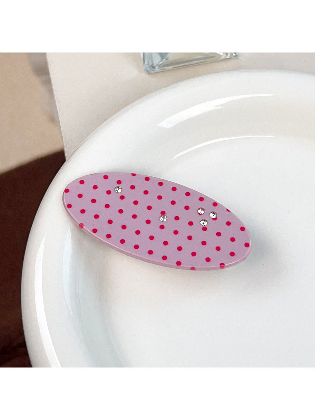 Beau pink polka dot hair claw clip displayed with matching hair accessories