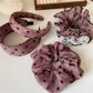 Polka dot ruffled scrunchie in black and white on a white background