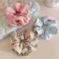 Gifty minimalist scrunchie with white and beige stripes on a white background