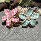Beau checkered flower shaped hair clip with black and white pattern on a white background
