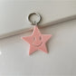 Silver star keychain hanging from a backpack zipper pull