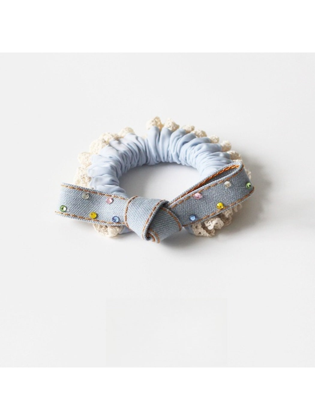 Bow hair ties in various colors stacked neatly on a white ceramic dish
