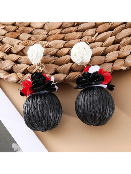Side view of Earedge raffia ball earrings showing fabric flower detail
