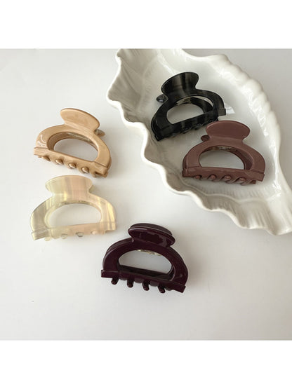 Beau vintage semi circular claw clip with intricate openwork design on a white background