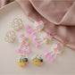 Close-up of small beaded flower-shaped earrings with white and gold beads