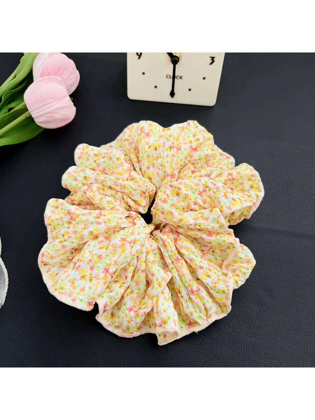 Black fabric scrunchie with white polka dots next to a small gift box
