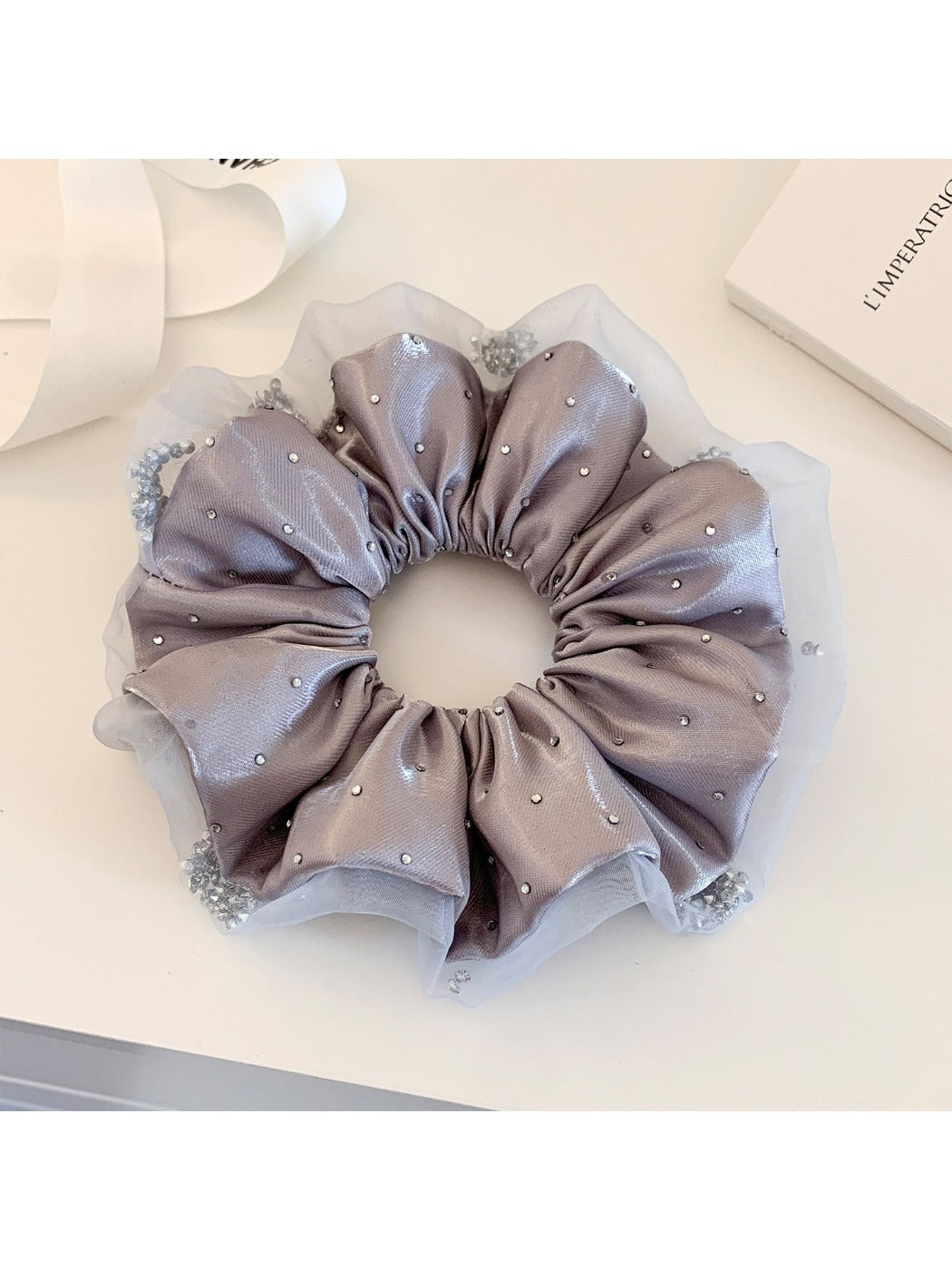 Pink satin ruched scrunchie displayed with matching hair accessories