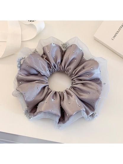 Pink satin ruched scrunchie displayed with matching hair accessories