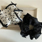 Close-up of Gifty elegant bow tulle scrunchie in soft pink on white background