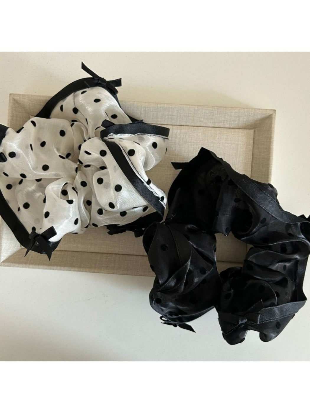 Close-up of Gifty elegant bow tulle scrunchie in soft pink on white background